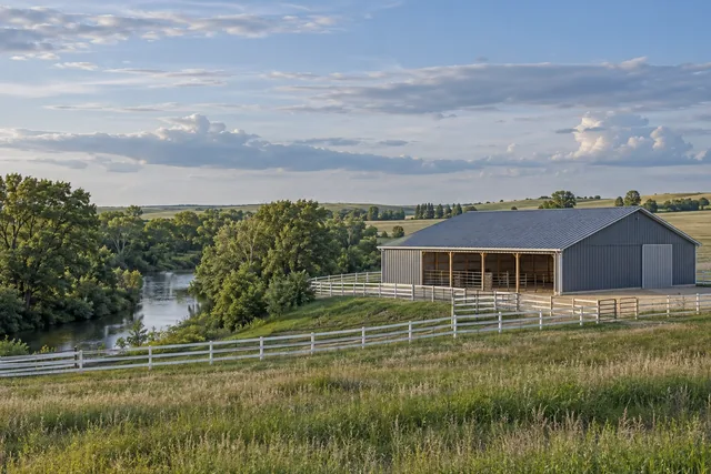 Sheyenne River valley with wooded riverbank, rolling ground and a horse property with white fencing